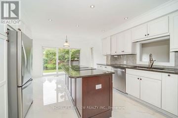 Richmond Hill (South Richvale) apartment for rent - A kitchen with white cabinets and a wooden island.
