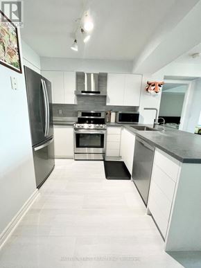 Toronto (Willowdale East) condo for rent - A modern kitchen with stainless steel appliances and white cabinets.