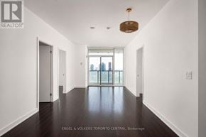 Toronto (Waterfront Communities) condo for rent - A long hallway with a wooden floor and white walls.