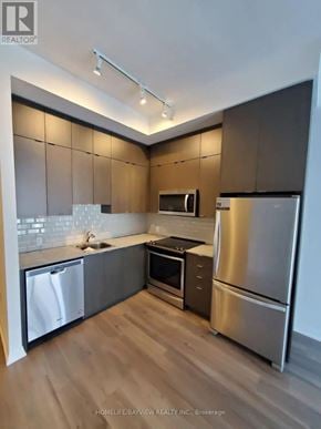 Toronto (Henry Farm) condo for rent - A modern kitchen with wooden cabinets and stainless steel appliances.