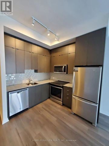 Toronto (Henry Farm) condo for rent - A modern kitchen with wooden cabinets and stainless steel appliances.