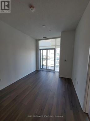 Toronto (Henry Farm) condo for rent - A spacious room with wooden floors and a large window.