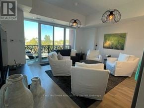 Collingwood condo for rent - A living room with white furniture and a large window.