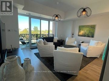 Collingwood condo for rent - A living room with white furniture and a large window.