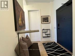 Collingwood condo for rent - A hallway with a black door, a white door, and a painting on the wall.
