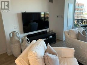 Collingwood condo for rent - A living room with a flat screen TV and a white couch.