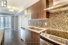 Toronto (Islington-City Centre West) condo for rent - A modern kitchen with wooden cabinets and a tiled backsplash.