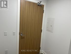 Vaughan (Concord) condo for rent - A wooden door with a silver handle and a small window above it.