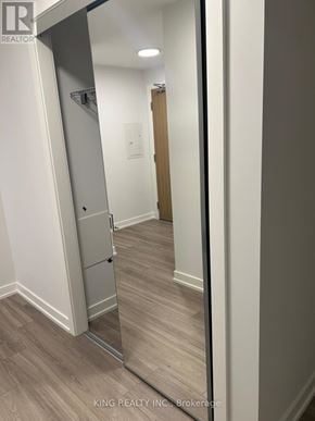 Vaughan (Concord) condo for rent - A hallway with a wooden door and a white wall.