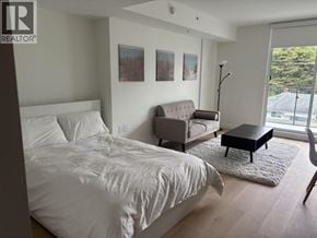 Vancouver apartment for rent - A bedroom with a bed, couch, and chair.