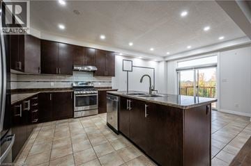 Waterloo apartment for rent - A kitchen with brown cabinets and a tile floor.