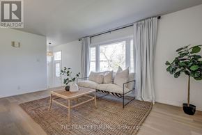 London South (South D) apartment for rent - A living room with a white couch, a wooden coffee table, and a potted plant.