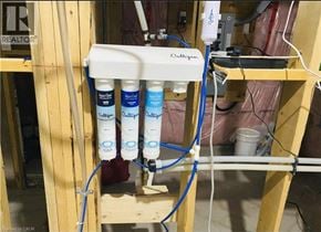 Kitchener apartment for rent - A water filtration system with four filters is installed in a room under construction.