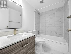 Toronto (Briar Hill-Belgravia) condo for rent - A bathroom with a marble tile wall and a white toilet.