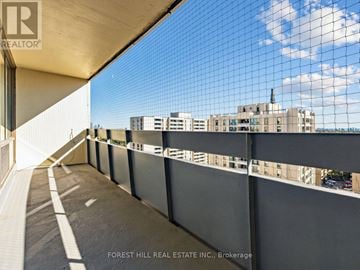 Toronto (Briar Hill-Belgravia) condo for rent - A balcony with a view of a cityscape and a building with a chimney.