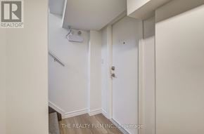 London South (South D) apartment for rent - A white door in a room with a Realty firm logo.