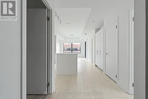Toronto (Thorncliffe Park) condo for rent - A hallway with white walls and a wooden floor leading to a room with a window.