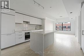 Toronto (Thorncliffe Park) condo for rent - A modern kitchen with white cabinets and a marble island.
