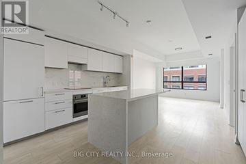 Toronto (Thorncliffe Park) condo for rent - A modern kitchen with white cabinets and a marble island.