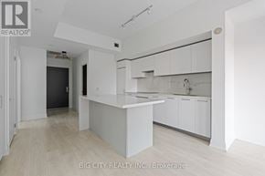 Toronto (Thorncliffe Park) condo for rent - A white kitchen with a countertop and cabinets.