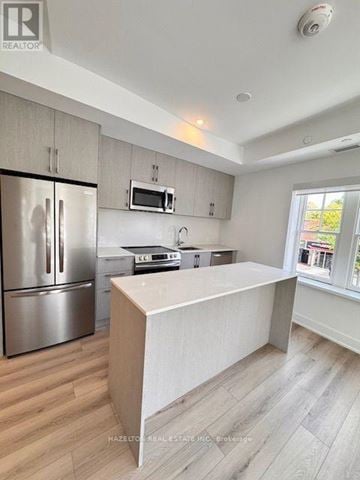 Toronto (Yonge-Eglinton) condo for rent - A modern kitchen with a refrigerator, microwave, and oven.