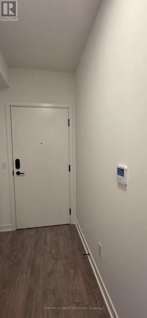 Brampton (Fletcher's Creek South) condo for rent - A white door with a black handle is in a room with a wooden floor.