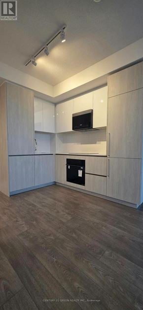Brampton (Fletcher's Creek South) condo for rent - A kitchen with white cabinets and a microwave.