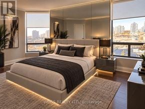 Vaughan (Brownridge) condo for rent - A bedroom with a large bed and a view of the city.