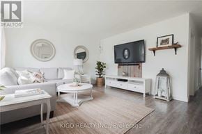 Burlington (Mountainside) apartment for rent - A living room with a white couch, a white coffee table, a white TV stand, and a white rug.