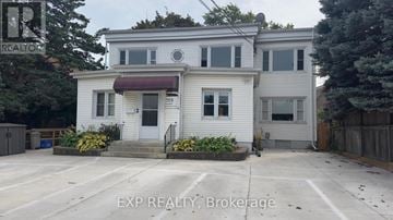St. Catharines (Old Glenridge) triplex for rent - A white house with a red awning is for sale.