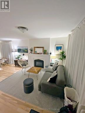 Toronto (Rosedale-Moore Park) apartment for rent - A living room with a grey couch and a wooden coffee table.