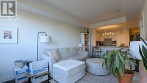 Oakville (Br Bronte) condo for rent - A living room with a grey sofa and a potted plant.