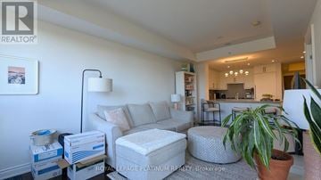 Oakville (Br Bronte) condo for rent - A living room with a grey sofa and a potted plant.