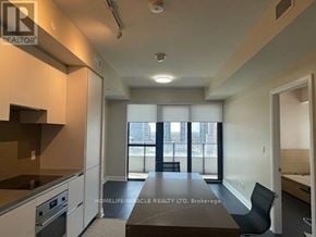 Mississauga (City Centre) condo for rent - A well-lit kitchen with a dining table and chairs.