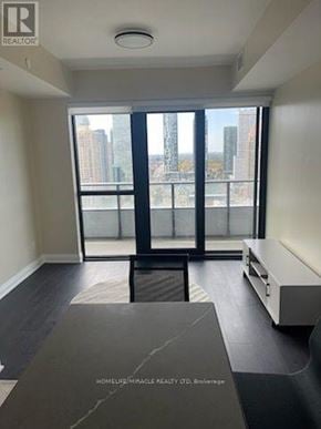 Mississauga (City Centre) condo for rent - A spacious room with a view of the city through large windows.