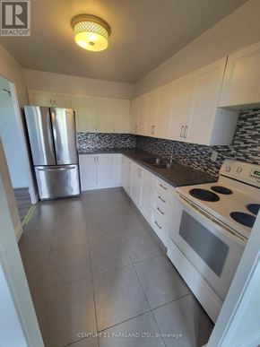 Toronto (Flemingdon Park) condo for rent - A kitchen with white cabinets and a stainless steel refrigerator.