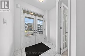 Centre Wellington (Fergus) apartment for rent - A white hallway with a black doormat and a brochure for RE/MAX Realty Specialists Inc. Brokerage.