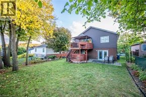Kitchener apartment for rent - A house with a deck and a tree with yellow leaves.