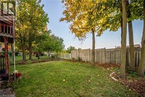 Kitchener apartment for rent - A backyard with a fence and trees.