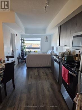 Brantford condo for rent - A kitchen with a wooden floor and a dining table with chairs.
