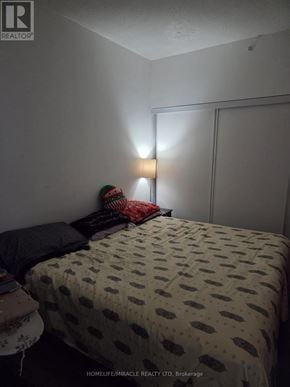 Brantford condo for rent - A bedroom with a bed covered in a polka dot comforter.