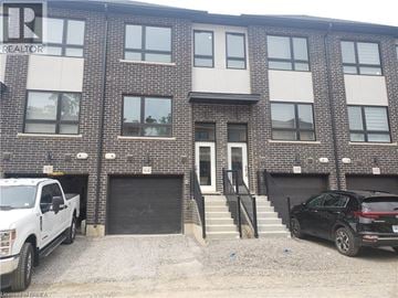Brantford townhouse for rent - A building with a realtor sign on the top left corner.