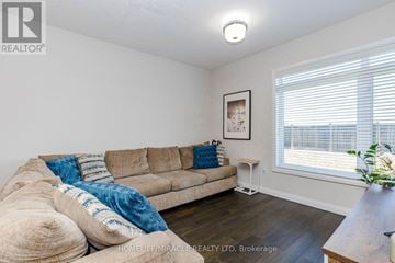 Hamilton (Stoney Creek) townhouse for rent - A living room with a beige couch and a wooden table.