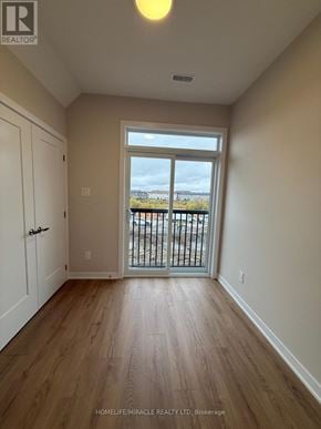 Ottawa townhouse for rent - A room with wooden floors and a sliding glass door leading to a balcony.