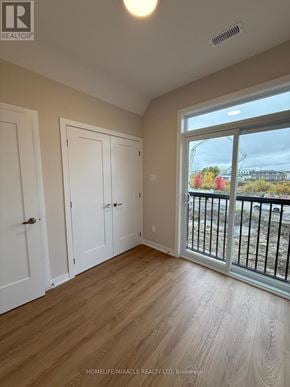 Ottawa townhouse for rent - A room with wooden floors and a view of a construction site through the window.