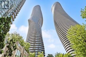 Mississauga (City Centre) condo for rent - Two tall buildings with striped facades stand next to each other.