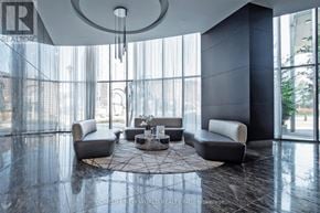 Mississauga (City Centre) condo for rent - A modern living room with a circular chandelier and grey sofas.