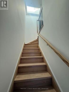 Toronto (University) apartment for rent - A staircase with wooden steps and a metal railing.