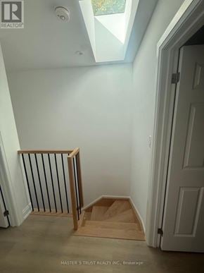 Toronto (University) apartment for rent - A white room with a skylight and a wooden staircase.