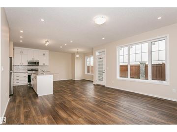 Edmonton apartment for rent - A spacious kitchen with white cabinets and a wooden floor.